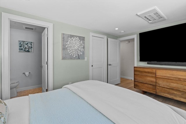 bedroom featuring baseboards, visible vents, ensuite bath, and recessed lighting