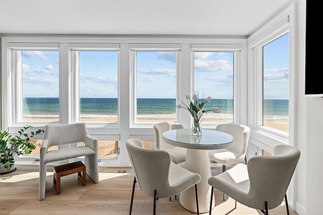 sunroom featuring a water view