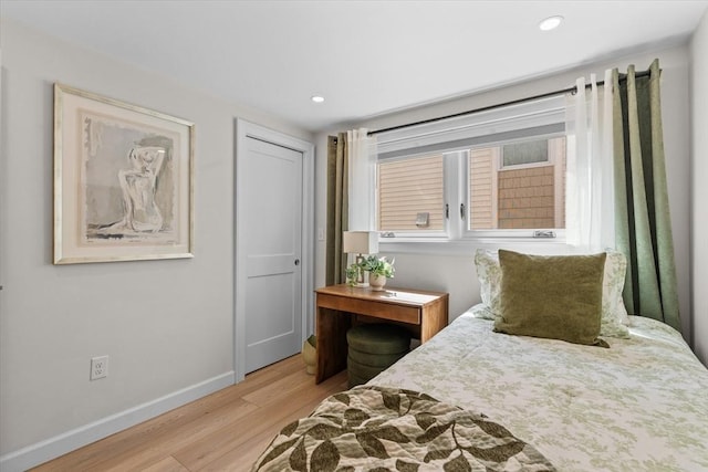 bedroom featuring light wood finished floors, recessed lighting, a closet, and baseboards