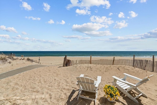 property view of water featuring fence and a view of the beach