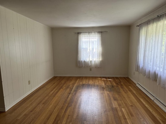 47 Mayfair St, East Longmeadow, MA 01028 - empty room featuring a baseboard radiator, hardwood / wood-style floors, and wooden walls