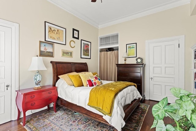 bedroom featuring crown molding, wood finished floors, and a ceiling fan