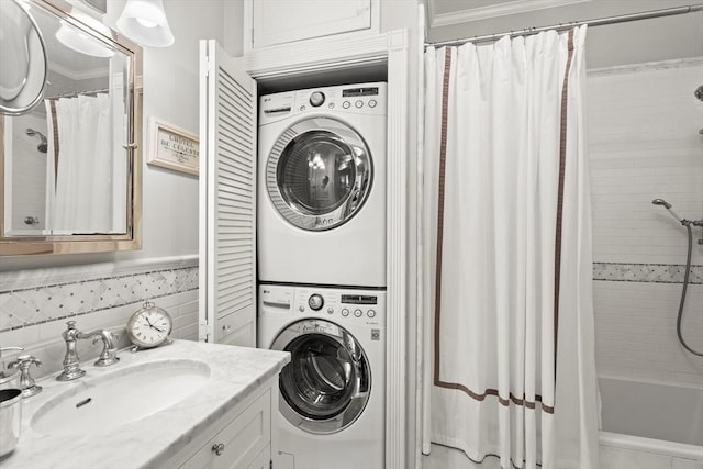 laundry room featuring stacked washer and clothes dryer and crown molding