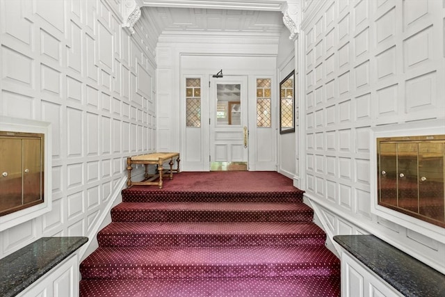 staircase with a decorative wall and carpet