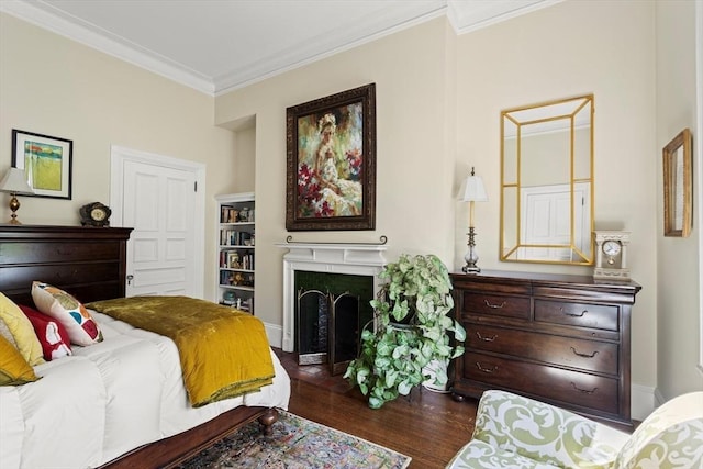 bedroom with crown molding, dark wood finished floors, and a fireplace