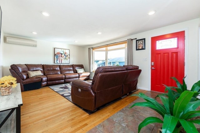 living room with an AC wall unit and hardwood / wood-style floors