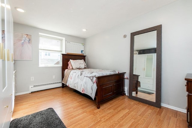 bedroom with a baseboard radiator and light hardwood / wood-style floors