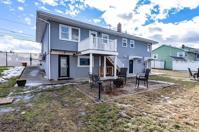 rear view of house with a patio area and an outdoor fire pit