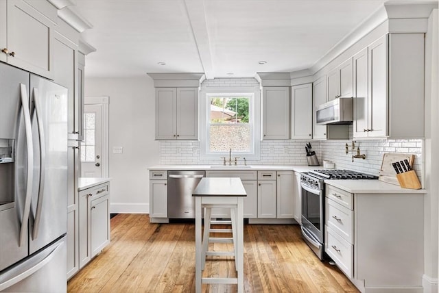 61 Elm St Unit 61, Andover, MA 01810 - kitchen with appliances with stainless steel finishes, light wood finished floors, decorative backsplash, and recessed lighting