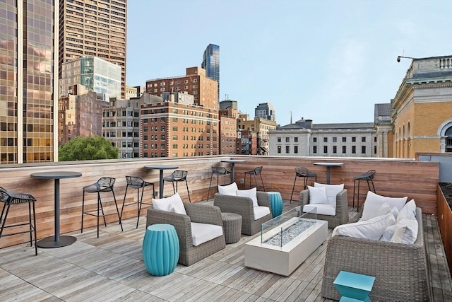 balcony with an outdoor living space with a fire pit and a city view