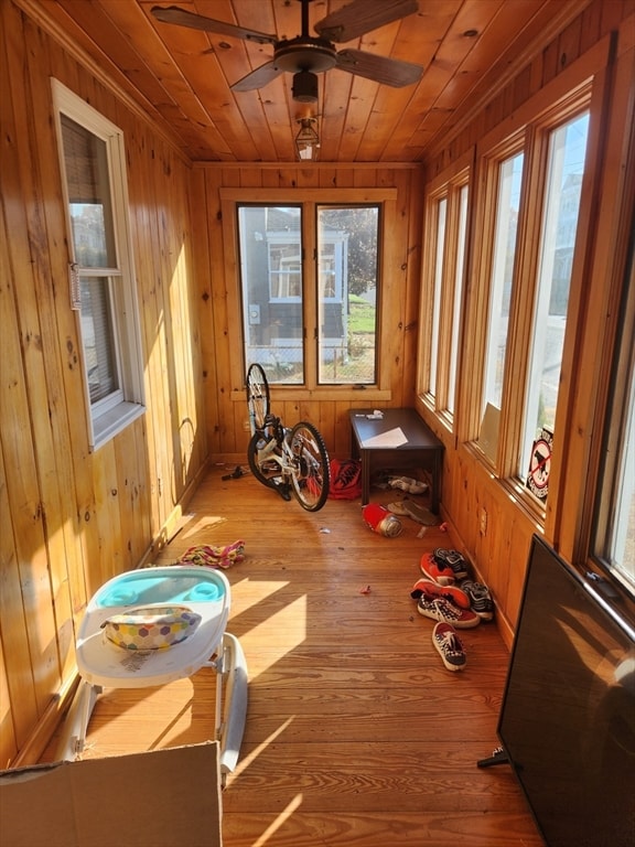 sunroom featuring ceiling fan, wood ceiling, and plenty of natural light