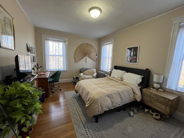 bedroom featuring ornamental molding and hardwood / wood-style floors