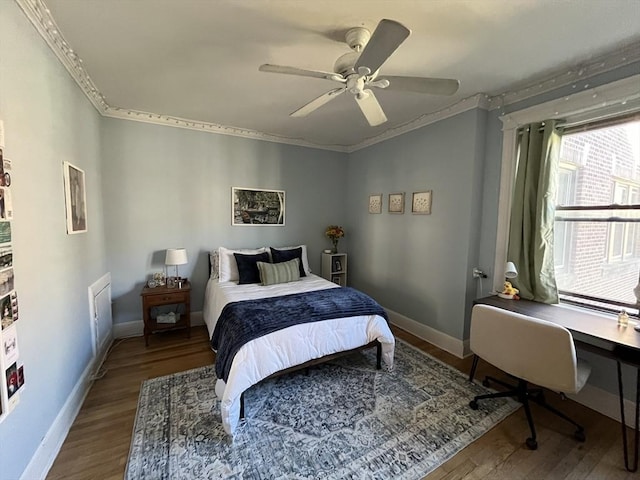 bedroom with hardwood / wood-style floors, ornamental molding, and ceiling fan