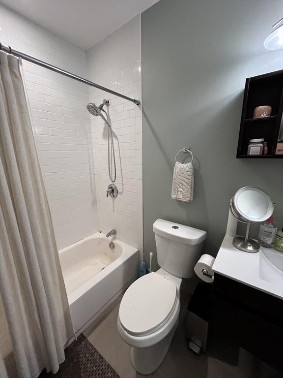 bathroom featuring shower / tub combo with curtain and toilet