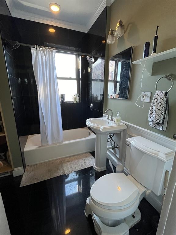 full bathroom with sink, ornamental molding, toilet, and shower / tub combo