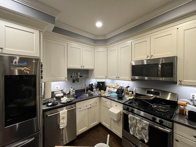 kitchen with sink, dark wood-type flooring, stainless steel appliances, cream cabinets, and ornamental molding