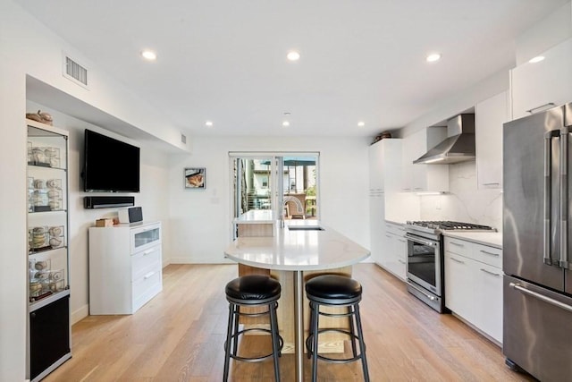 288 Marginal St Unit 4, Boston, MA 02128 - kitchen with appliances with stainless steel finishes, wall chimney exhaust hood, white cabinetry, light countertops, and modern cabinets