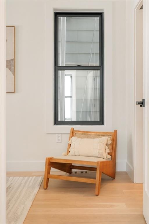 living area featuring baseboards and wood finished floors