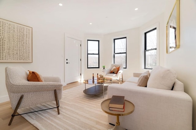 living room featuring light wood finished floors, recessed lighting, and baseboards