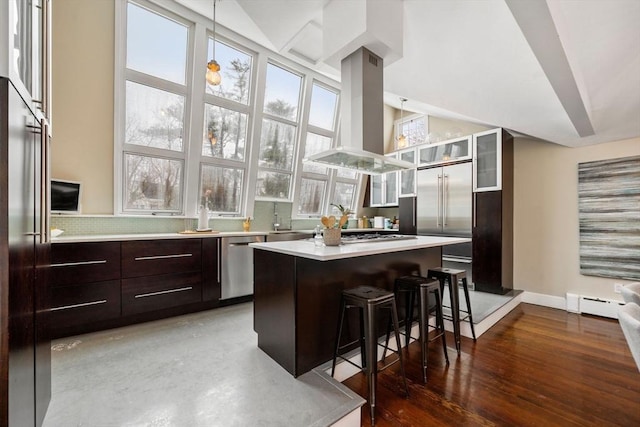 kitchen featuring island range hood, glass insert cabinets, a breakfast bar area, a center island, and stainless steel appliances