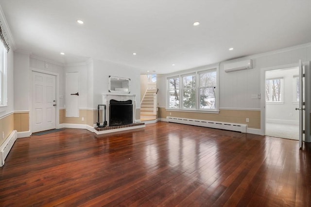 unfurnished living room featuring a fireplace with raised hearth, a baseboard heating unit, wood finished floors, baseboard heating, and a wall mounted AC