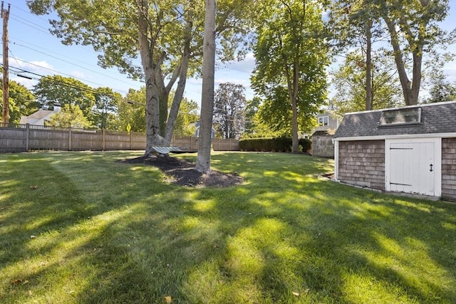 view of yard featuring a storage shed, an outbuilding, and a fenced backyard