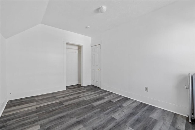 additional living space featuring dark hardwood / wood-style floors and vaulted ceiling