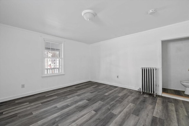 empty room with ornamental molding, dark hardwood / wood-style floors, and radiator