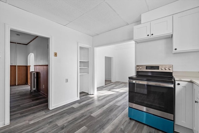 kitchen with white cabinetry, dark hardwood / wood-style floors, a paneled ceiling, and stainless steel range with electric cooktop