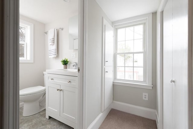 bathroom featuring vanity, plenty of natural light, and toilet