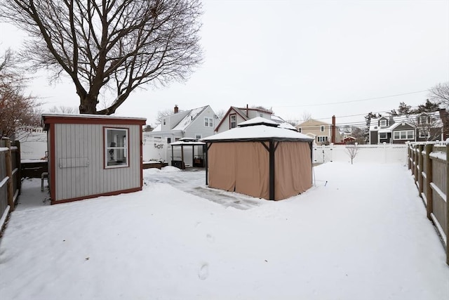 yard covered in snow featuring a storage shed