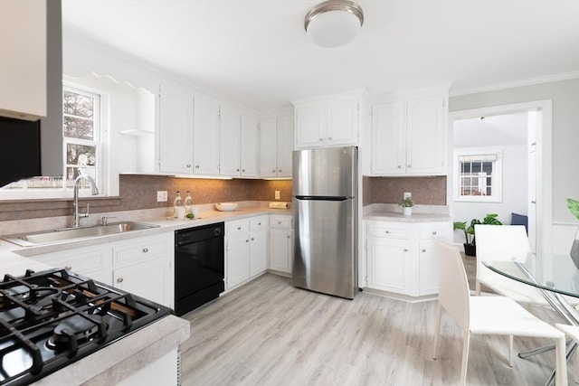 kitchen with stainless steel refrigerator, white cabinetry, dishwasher, sink, and decorative backsplash