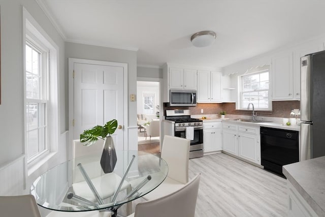 kitchen featuring appliances with stainless steel finishes, sink, white cabinets, and plenty of natural light