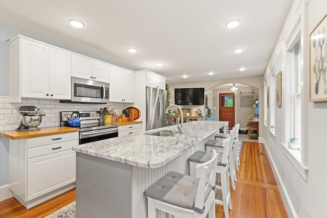 965 Greenville Ave, Smithfield, RI 02828 - kitchen with appliances with stainless steel finishes, arched walkways, light wood-style floors, backsplash, and recessed lighting