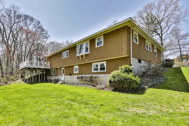 rear view of house featuring a lawn, central air condition unit, and a deck