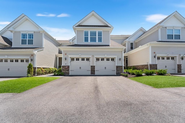 27 Richardson Dr Unit 27, Millis, MA 02054 - view of front facade featuring asphalt driveway, a garage, stone siding, and a front yard