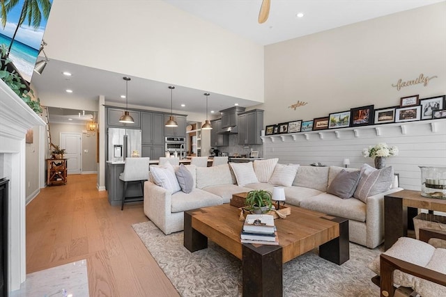 27 Richardson Dr Unit 27, Millis, MA 02054 - living room with a towering ceiling, light wood finished floors, a glass covered fireplace, and recessed lighting