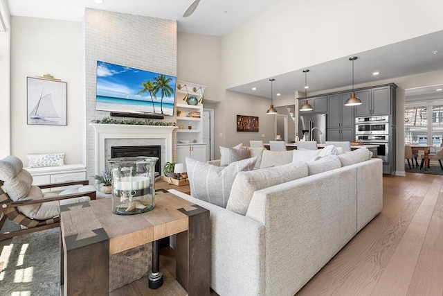27 Richardson Dr Unit 27, Millis, MA 02054 - living room with light wood-type flooring, a high ceiling, a high end fireplace, and recessed lighting