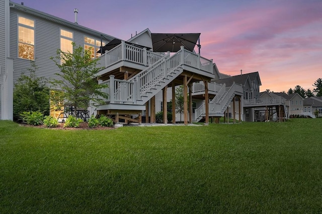 27 Richardson Dr Unit 27, Millis, MA 02054 - back of house at dusk featuring stairs, a deck, and a lawn
