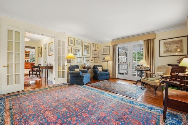 sitting room with french doors, crown molding, and wood finished floors