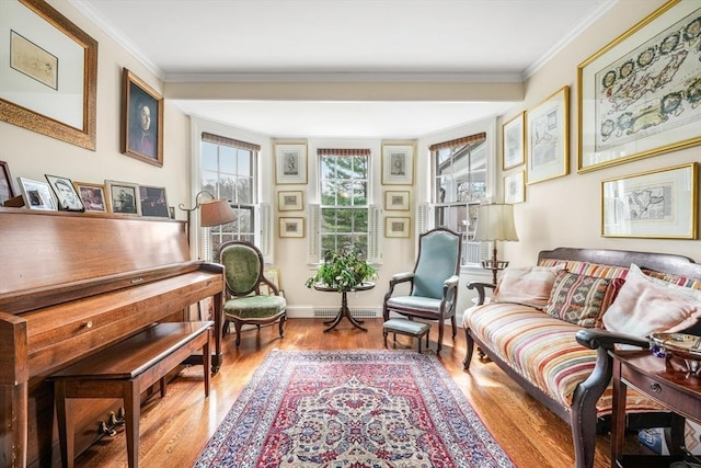 sitting room with wood finished floors, ornamental molding, and baseboards