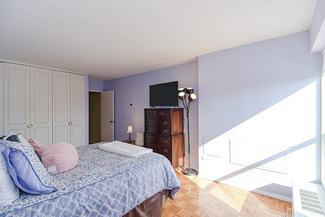 bedroom featuring a closet and light parquet flooring