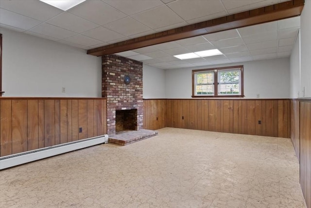 479 W, West Bridgewater, MA 02379 - unfurnished living room featuring wainscoting, wood walls, a baseboard radiator, a paneled ceiling, and a brick fireplace