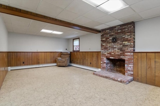 479 W, West Bridgewater, MA 02379 - below grade area featuring a wainscoted wall, wood walls, a baseboard heating unit, a paneled ceiling, and a brick fireplace