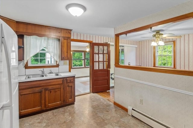 479 W, West Bridgewater, MA 02379 - kitchen with a ceiling fan, a baseboard heating unit, wallpapered walls, a sink, and brown cabinets