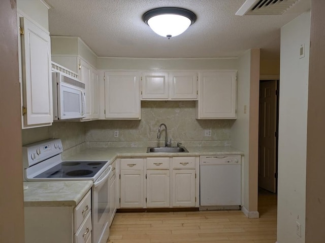 42 Old Colony Way Unit 30, Orleans, MA 02653 - kitchen with white appliances, light wood-style flooring, light countertops, a textured ceiling, and white cabinets