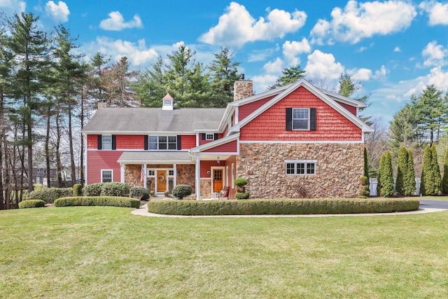 craftsman house featuring a front yard, stone siding, and a chimney