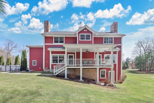 view of front of property featuring a front yard, a chimney, and a ceiling fan