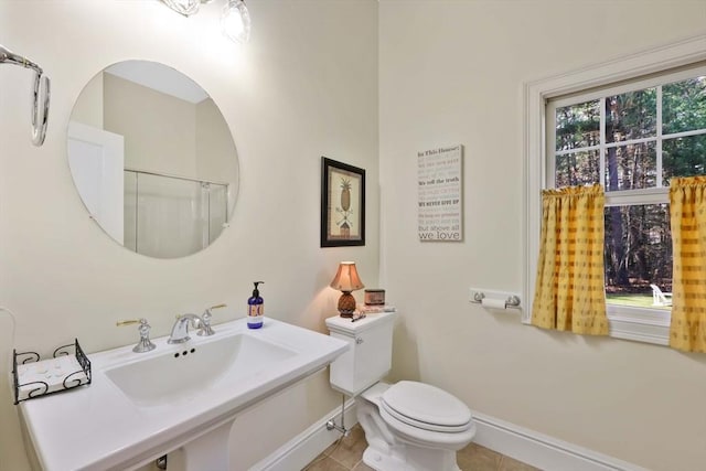bathroom featuring toilet, tile patterned floors, a sink, and baseboards