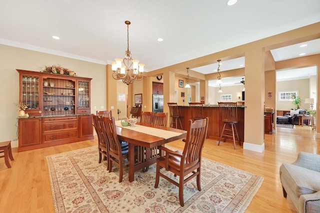 dining room featuring recessed lighting, a notable chandelier, light wood-type flooring, and crown molding